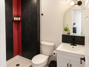 a bathroom with a toilet and a sink and a mirror at The Creative Escape With Community Canvas Loft in Coeur d'Alene