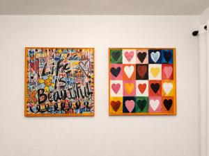 two pieces of art on a wall with hearts at The Creative Escape With Community Canvas Loft in Coeur d'Alene +5 photos