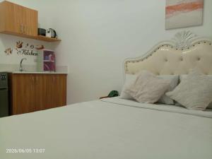 a bedroom with a white bed with a white bedspread at Grand Riviera neas Slec in Manila