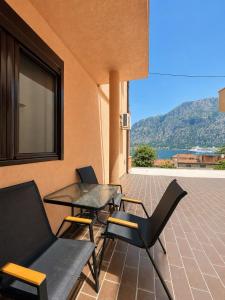 a patio with two chairs and a table and a window at Grifon 72 Apartments in Prčanj