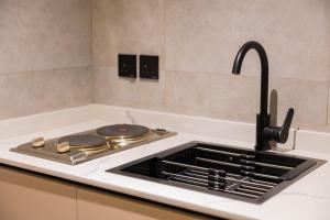 a kitchen counter with a sink and a stove at فندق لامار بارك - العليا in Tabuk +13 photos
