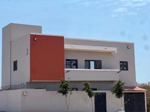 a white building with a red door on it at Villa Jose in Sindia