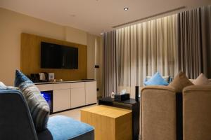 a living room with two chairs and a flat screen tv at فندق لامار بارك - العليا in Tabuk