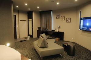 a living room with a couch and a flat screen tv at グランマリーナホテル in Osaka