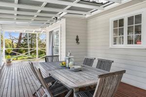a wooden table and chairs on a porch at Sutton House Southern Highlands in Moss Vale