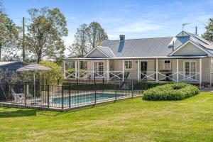 a house with a fence in front of a yard at Sutton House Southern Highlands in Moss Vale