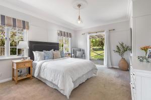 a white bedroom with a bed and a window at Sutton House Southern Highlands in Moss Vale +23 photos