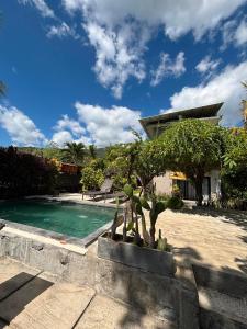 a swimming pool with a statue next to a house at Bali Yogi in Amed