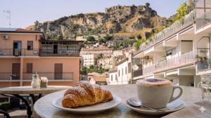 a table with a cup of coffee and two croissants at The Best Bed & Breakfast in Amantea