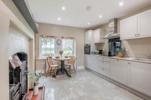 a kitchen with white cabinets and a table with chairs at 3 Bed in Fulbeck oc-v33643 in Fulbeck