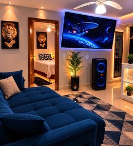 a living room with a blue couch and a bedroom at diRoma Luxo Oficial Apt mais diRoma Acqua Park e Splash e Slide , 3 parques Aquáticos , Roupa de Cama e Toalhas, Parcelamos até 12x no Cartão de Crédito sem Juros , Aceitamos Pet in Caldas Novas