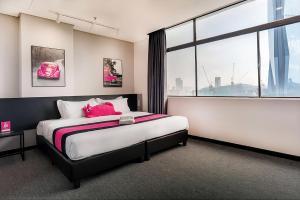 a bedroom with a bed and a large window at Apex by Bukit Bintang Hotel in Kuala Lumpur