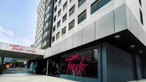 a store front of a building with a neon sign in the window at Apex by Bukit Bintang Hotel in Kuala Lumpur