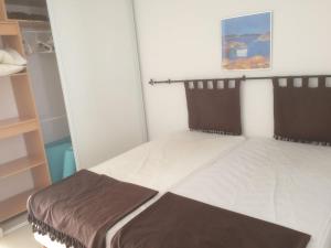 a small bedroom with a bed with brown pillows at Monte san petru in Propriano