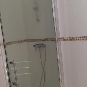a shower with a glass door with a shower head at Monte san petru in Propriano