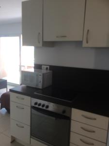 a kitchen with white cabinets and a stove top oven at Monte san petru in Propriano +4 photos