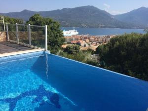 a large blue swimming pool with a view of a city at Monte san petru in Propriano