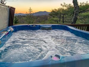 a jacuzzi tub filled with snow with the sunset at Angels Envy in Lenoir