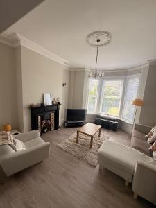 a living room with a couch and a table at Cosy 4 bedroom house in Marshside