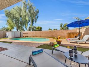 a swimming pool with a table and chairs and an umbrella at Karsten Maricopa in Maricopa