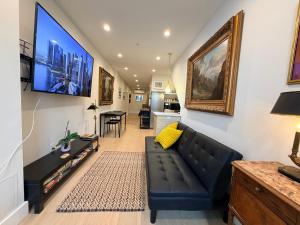 a living room with a black couch and a flat screen tv at The Hudson Horizon in West New York