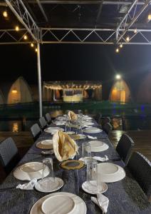 a long table with plates and glasses on it at Reef Resort - Mount Apo View Unit B3 in Kaputian