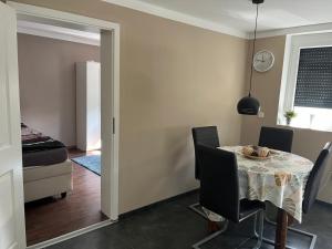 a dining room with a table and chairs and a bedroom at FeWo Steineck leutenberg in Leutenberg