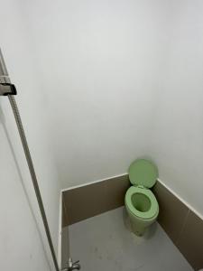 a bathroom with a green toilet in a stall at Kwarto-2-Go in Pontud