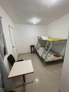 a room with two bunk beds and a table at Kwarto-2-Go in Pontud