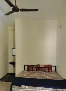 a bedroom with a bed with a ceiling fan at The beach light in Auroville