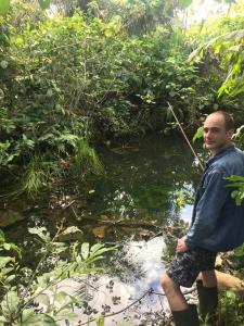 a man standing in front of a stream at Sisa Lodge in Tena