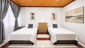 two beds in a room with two windows at Urban House in Florencia