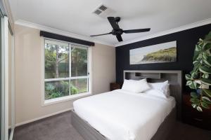 a bedroom with a white bed and a window at Chelsea Poolside and Tennis in Nelson Bay +27 photos
