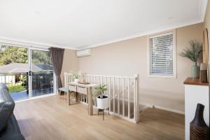 a living room with a table and a dining room at Chelsea Poolside and Tennis in Nelson Bay