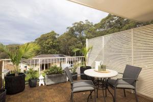 a patio with a table and chairs and plants at Chelsea Poolside and Tennis in Nelson Bay