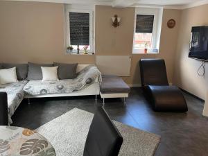 a living room with a couch and a tv at FeWo Steineck leutenberg in Leutenberg