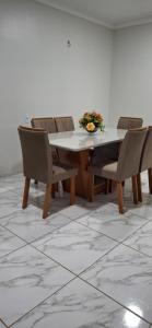 a dining room table and chairs with flowers on it at Casa Selma Ubajara in Ubajara
