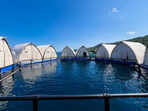 a row of white domes in the water at Reef Resort - Pearl Farm Resort View B5 in Kaputian