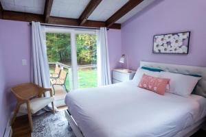 a bedroom with a white bed and a window at Dip and Dink Catskills Poolside Oasis in White Lake +27 photos