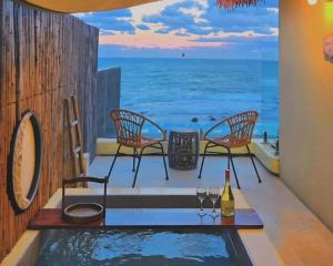 a pool with two chairs and a table with wine glasses at Ulsan Guyu Stay in Ulsan