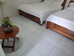 a bedroom with a bed and a table with a potted plant at Tam hien ho in Tân Hiệp