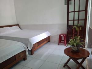 a bedroom with a bed and a table with a plant at Tam hien ho in Tân Hiệp