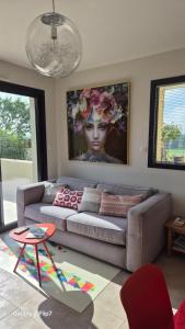 a living room with a couch and a painting on the wall at AU GRAIN D'ORGE in Échiré
