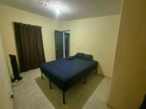a bedroom with a blue bed in a room at Hospedaje Dinos in Veracruz
