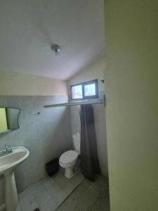 a bathroom with a toilet and a sink and a window at Hospedaje Dinos in Veracruz +6 photos