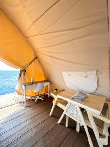a tent on a boat with a table and a desk at Reef Resort - Samal Island View Unit B7 in Kaputian
