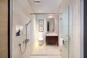 a bathroom with a shower and a toilet and a sink at Vasa Suite Surabaya in Surabaya