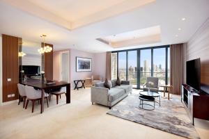 a living room with a couch and a table at Vasa Suite Surabaya in Surabaya