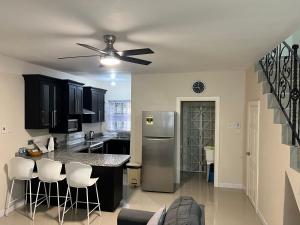 a kitchen with a stainless steel refrigerator and white stools at Mandeville ingleside luxury in Mandeville