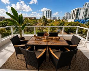 a table and chairs on a balcony with a view of a city at Oasis on Monroe Aparthotel in Hollywood